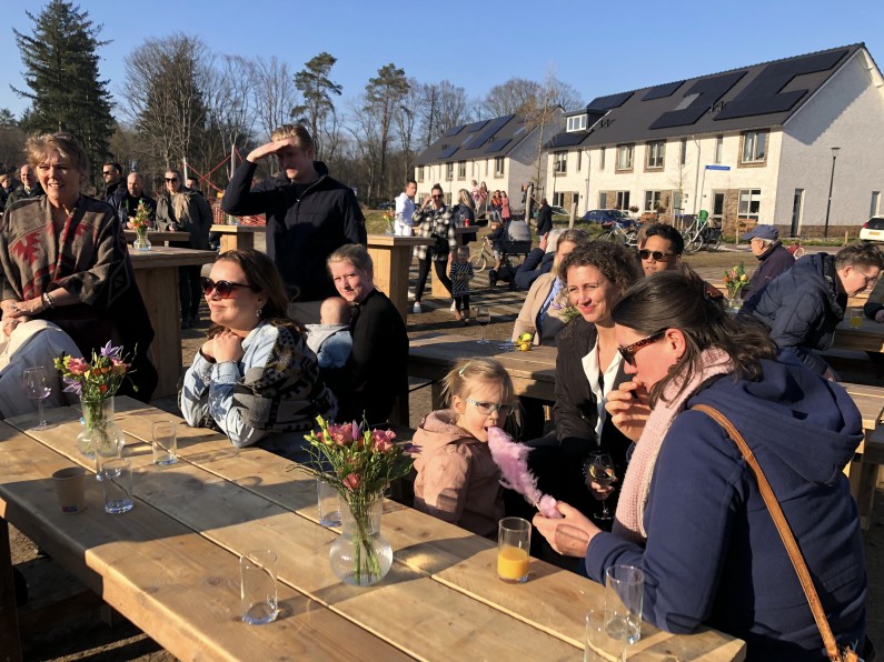 Mensen zitten buiten in de zon aan een tafel