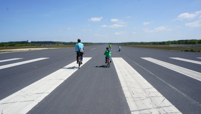 Vier fietsers op een landingsbaan
